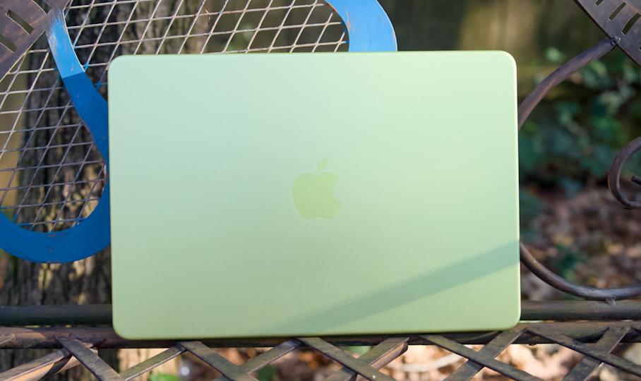 جهاز MacBook Neo بالحمضيات على طاولة بالخارج.
