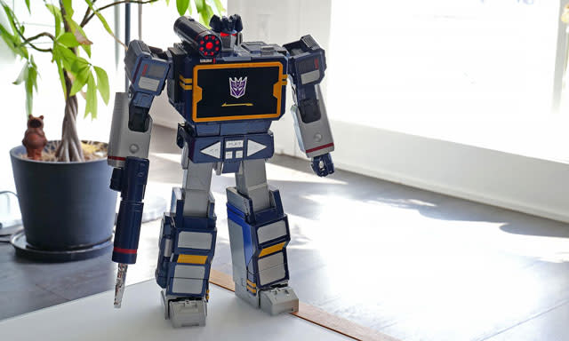 صورة Robosen Soundwave تقف أمام أحد النباتات.