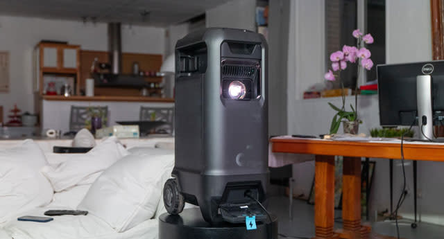 صورة Soundcore Nebula X1 على منصة في وسط غرفة معيشة فرنسية جميلة