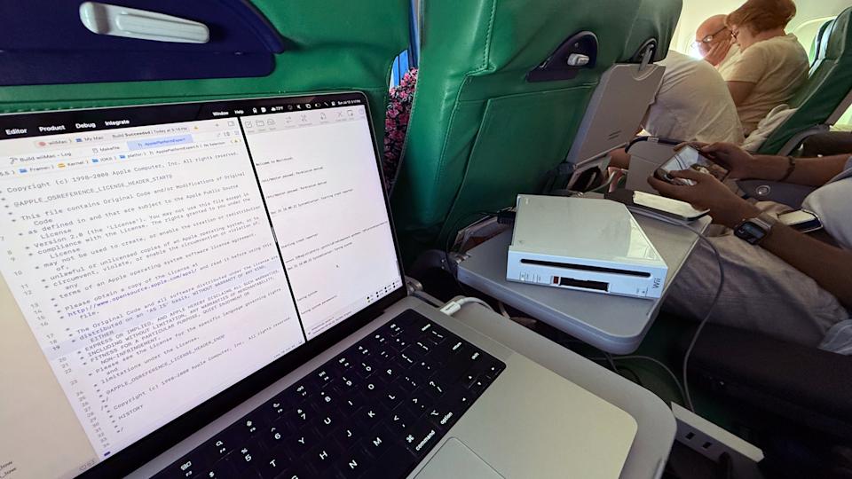 صورة لطائرة، حيث يوجد جهاز Wii بجوار جهاز MacBook مع وجود رمز على شاشته