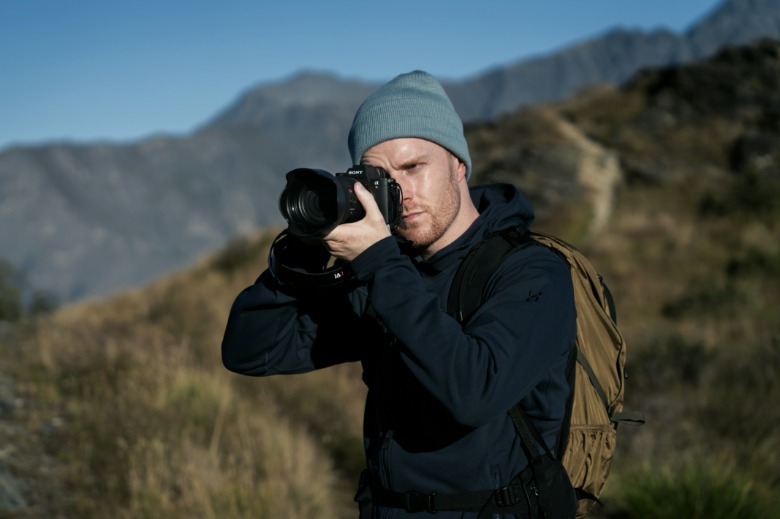 مصور يستخدم كاميرا Sony A7R VI في بيئة جبلية