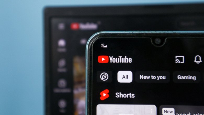 رمز تطبيق YouTube على هاتف ذكي مع موقع الويب الخاص به كخلفية