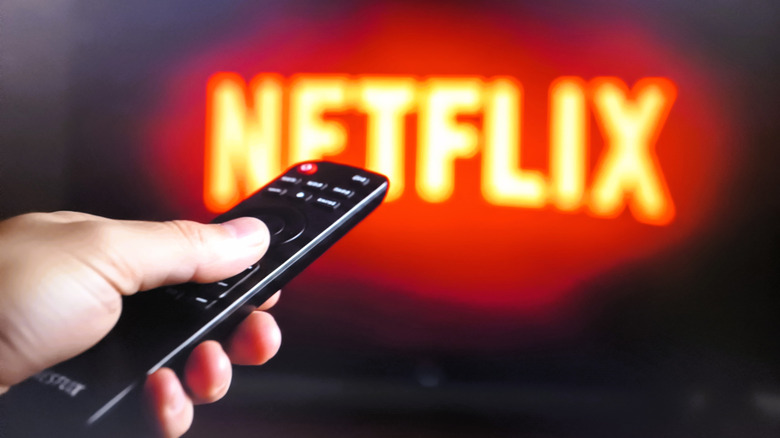 صورة مقربة لليد باستخدام جهاز التحكم عن بعد للتنقل في Netflix
