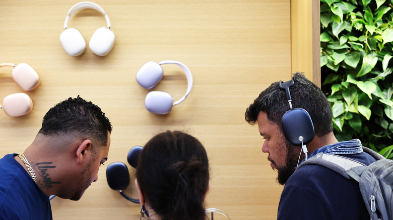 عملاء يرتدون AirPods Max في أحد متاجر Apple.