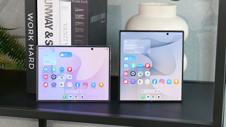 هاتفي Samsung Galaxy Z Fold 8 وZ Fold 8 Ultra على طاولة بها كتب ومزهرية في الخلفية.