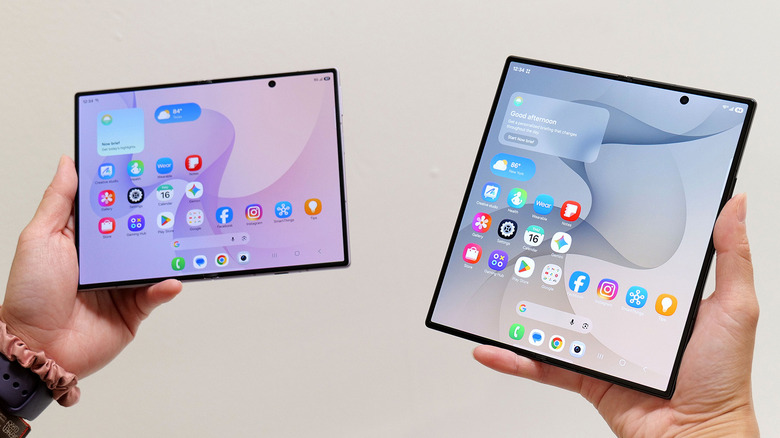 تم رفع هاتفي Samsung Galaxy Z Fold 8 وZ Fold 8 Ultra وفتحهما أمام جدار أبيض.